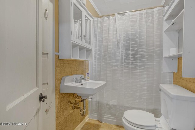 full bathroom featuring sink, shower / tub combo with curtain, tile patterned flooring, and toilet