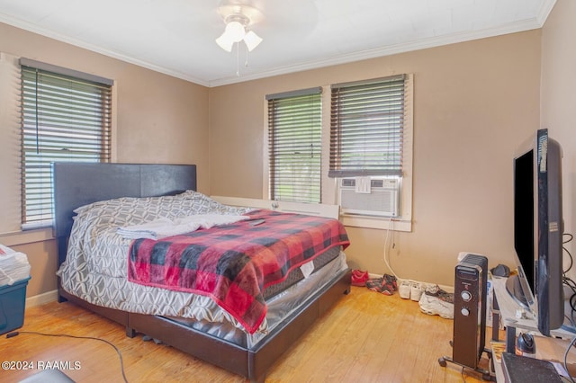 bedroom with hardwood / wood-style floors, cooling unit, ceiling fan, and crown molding