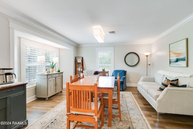 dining space featuring ornamental molding and light wood-type flooring