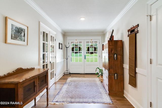 entryway featuring crown molding, light hardwood / wood-style flooring, and french doors