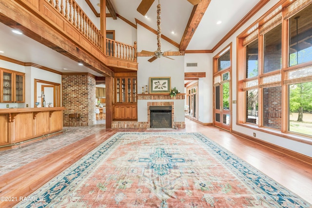 living room with high vaulted ceiling, a brick fireplace, hardwood / wood-style floors, and ceiling fan