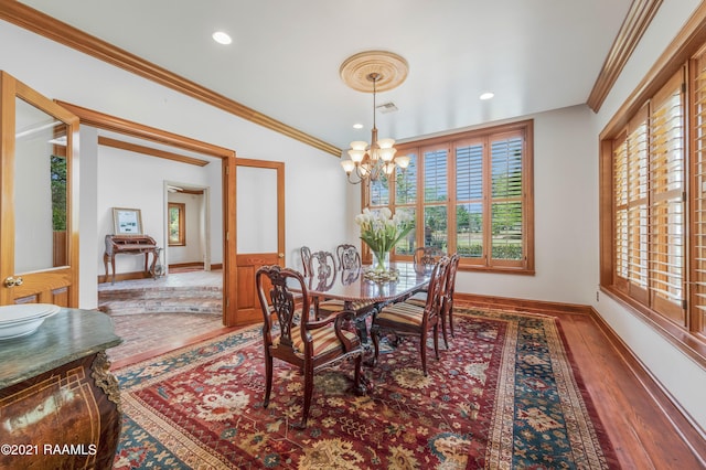 dining space with a chandelier, crown molding, vaulted ceiling, and hardwood / wood-style floors