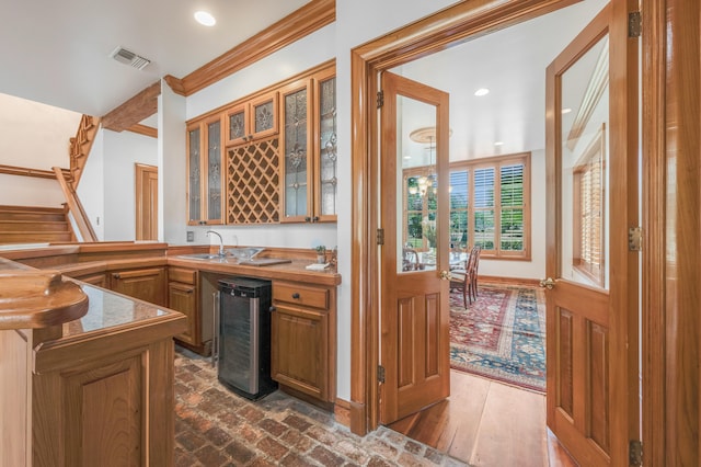 kitchen featuring sink, beverage cooler, and crown molding