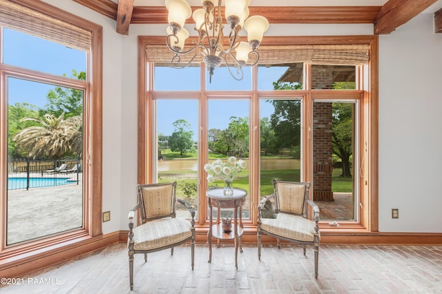 unfurnished room with plenty of natural light, beam ceiling, ornamental molding, and a chandelier