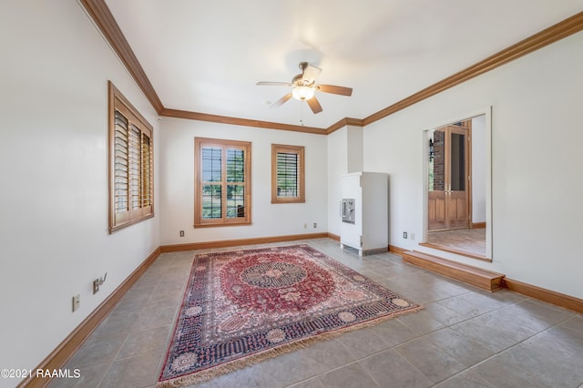 tiled spare room featuring ornamental molding and ceiling fan