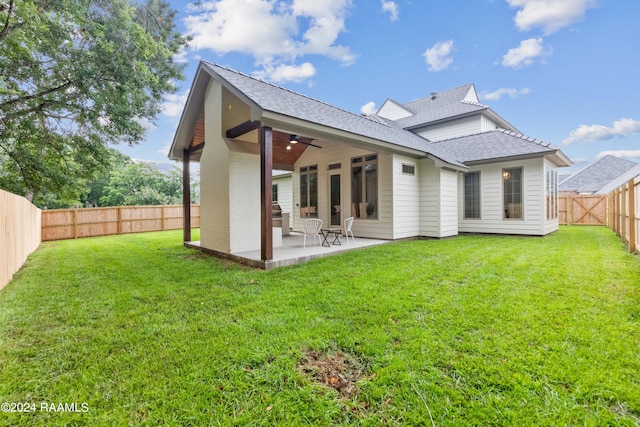 rear view of house with a yard, ceiling fan, and a patio area