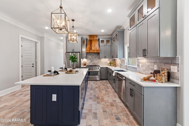 kitchen with appliances with stainless steel finishes, ornamental molding, custom range hood, a center island, and hanging light fixtures