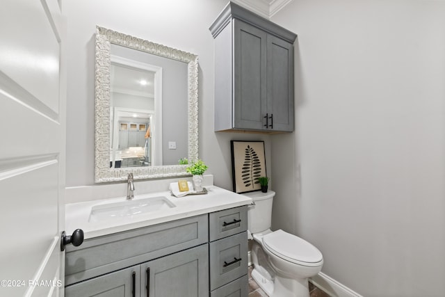 bathroom with vanity, toilet, and ornamental molding