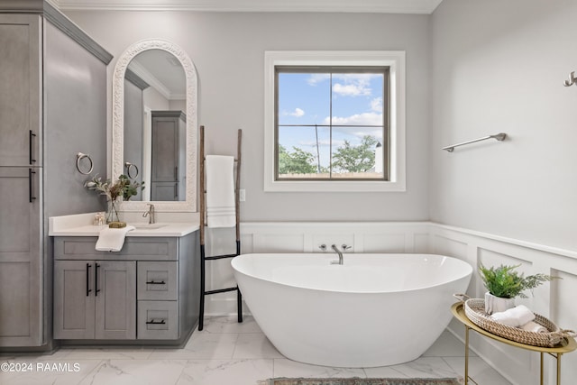 bathroom featuring a bathtub, ornamental molding, and vanity