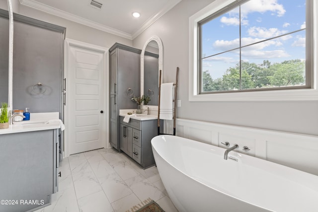 bathroom with a bathing tub, vanity, and crown molding