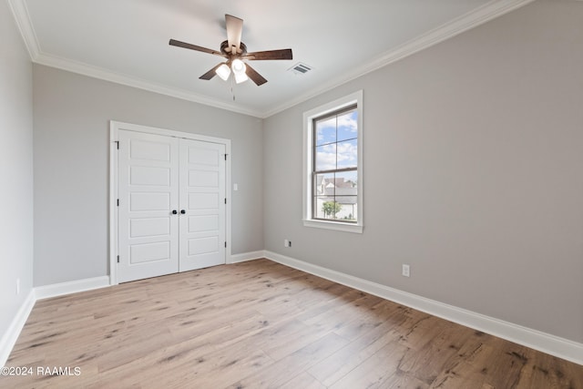 unfurnished bedroom with ceiling fan, a closet, crown molding, and light hardwood / wood-style flooring