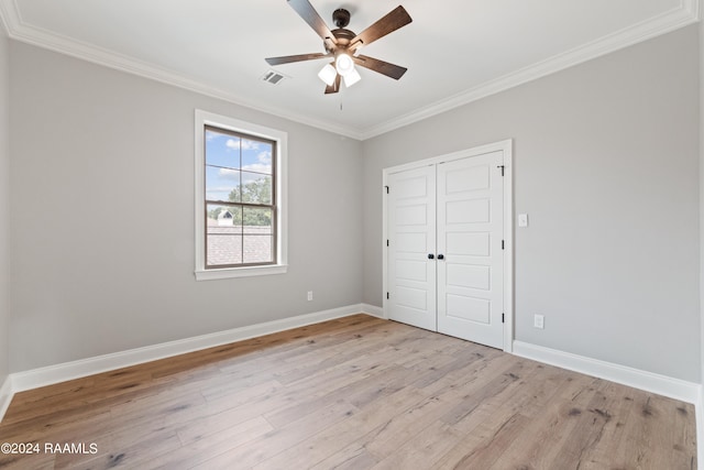 unfurnished bedroom featuring ceiling fan, light hardwood / wood-style floors, ornamental molding, and a closet