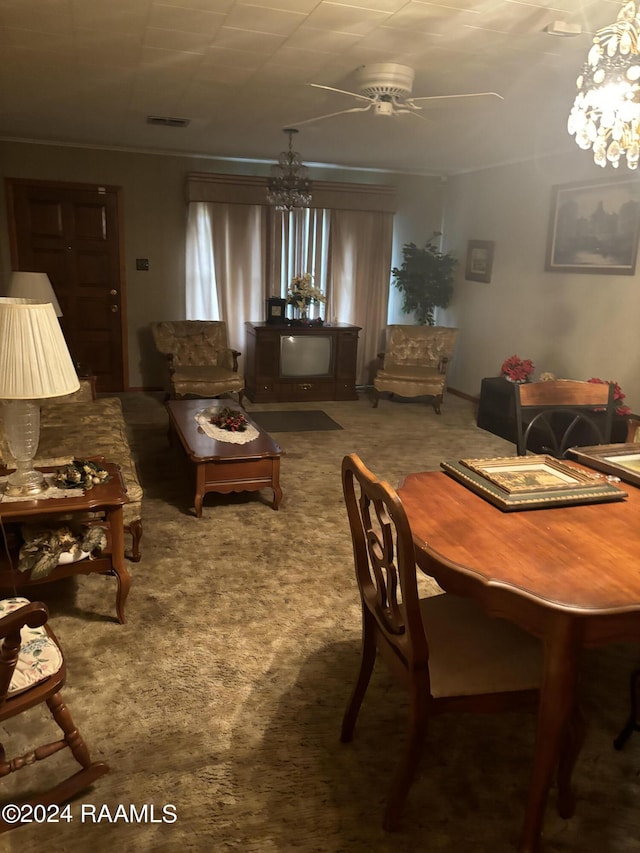 carpeted dining area featuring ceiling fan with notable chandelier