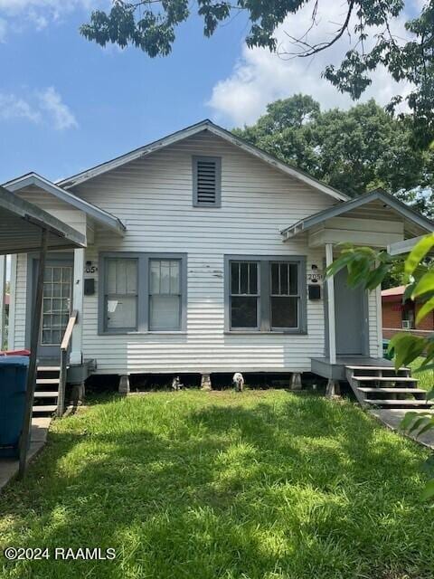 rear view of property with a lawn