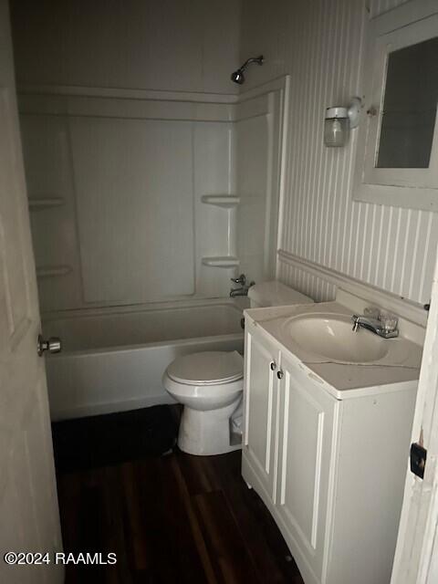 full bathroom with hardwood / wood-style floors, vanity, toilet, and  shower combination