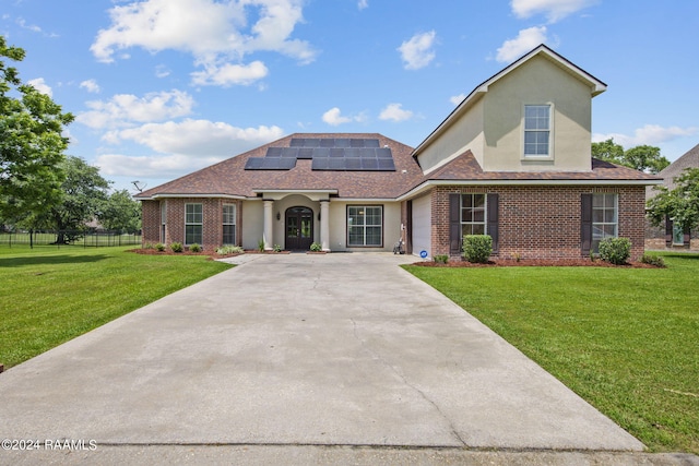 view of front facade with a front lawn and solar panels