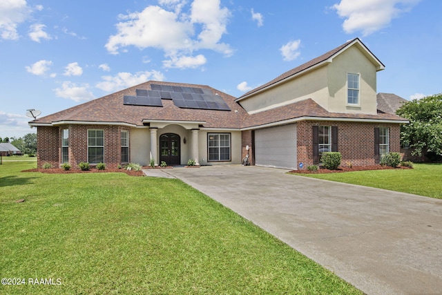 view of front of home with a front yard, a garage, and solar panels