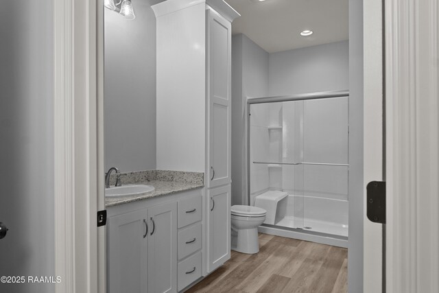 210 E D St, Rayne, LA 70578 - bathroom featuring vanity, wood finished floors, a shower stall, and toilet