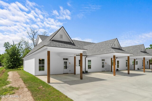 210 E D St, Rayne, LA 70578 - back of house featuring a carport, a patio area, and a shingled roof