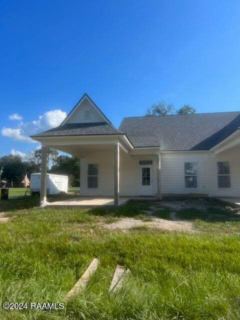 back of house featuring a lawn and a patio