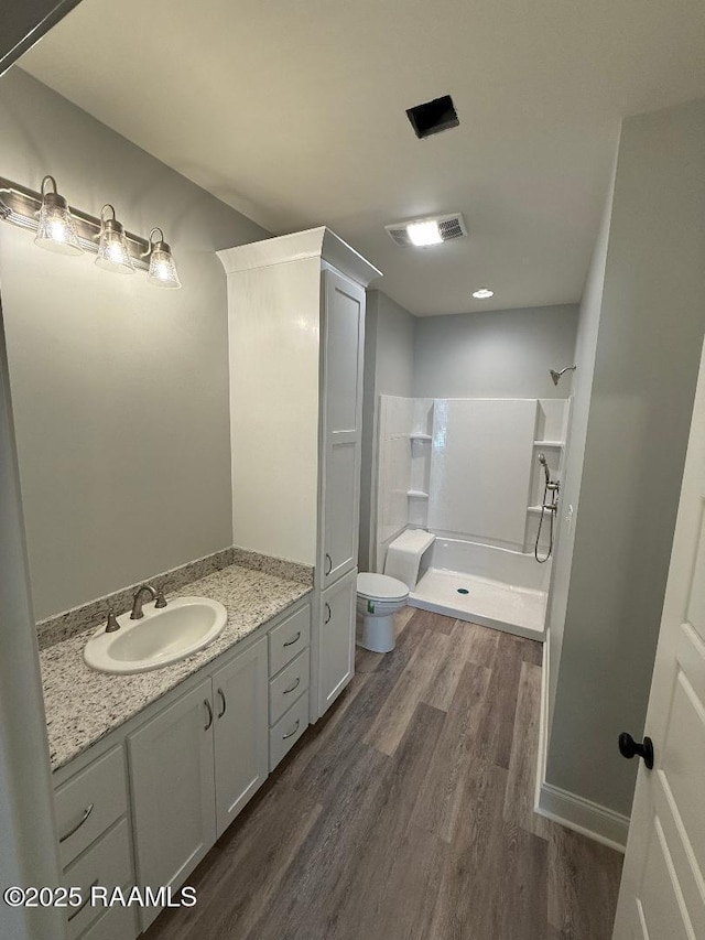 full bathroom with toilet, wood finished floors, visible vents, vanity, and a shower stall