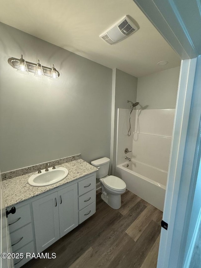 full bath with shower / bathtub combination, visible vents, toilet, vanity, and wood finished floors