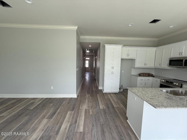 kitchen featuring white cabinets, dark wood-style floors, appliances with stainless steel finishes, ornamental molding, and light stone countertops