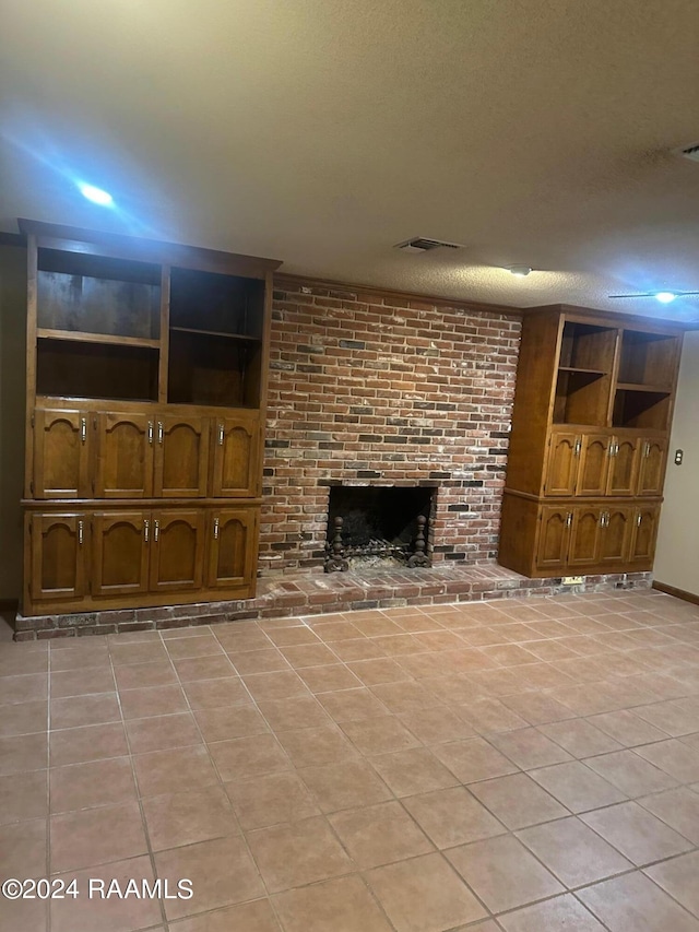 unfurnished living room featuring light tile floors, brick wall, and a brick fireplace