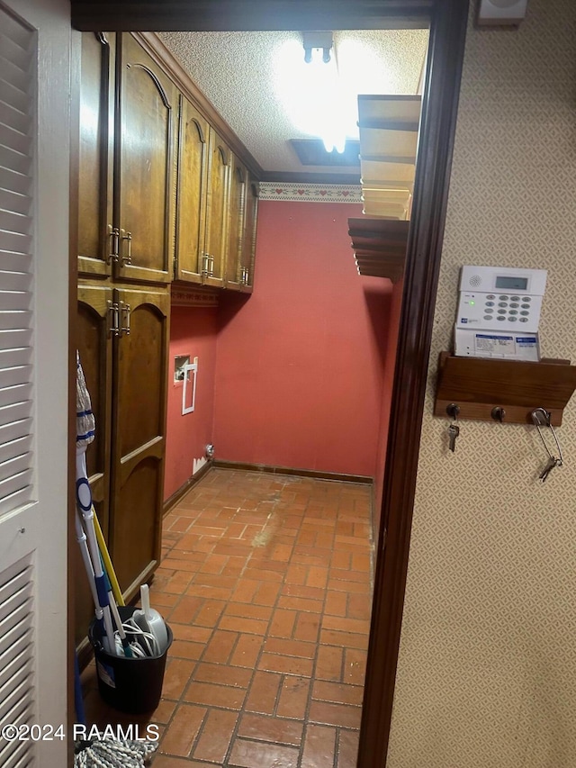 laundry area with cabinets, a textured ceiling, and hookup for a washing machine