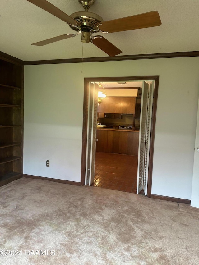 carpeted spare room with ceiling fan