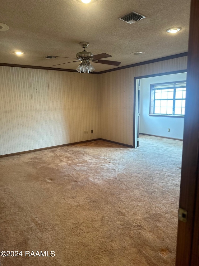 carpeted empty room featuring ceiling fan and a textured ceiling