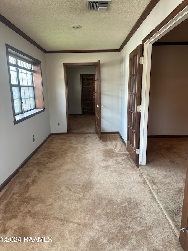 unfurnished bedroom with ornamental molding, carpet flooring, and a textured ceiling