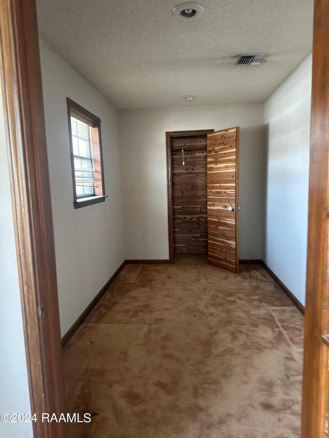 unfurnished bedroom featuring a textured ceiling and carpet flooring