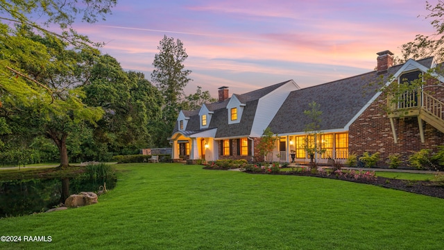 120 Kimball Dr, Lafayette, LA 70508 - back of house at dusk with a chimney, a yard, and brick siding