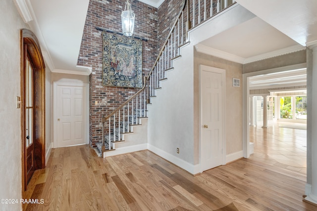 entrance foyer featuring decorative columns, crown molding, and wood-type flooring