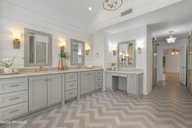 bathroom featuring vanity, lofted ceiling, and wood walls