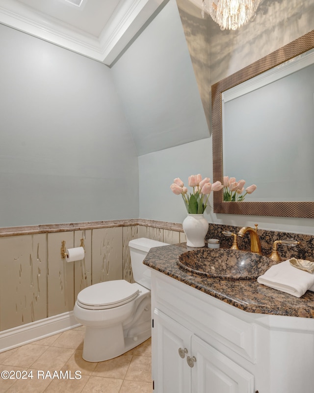 bathroom featuring vanity, lofted ceiling, crown molding, tile patterned flooring, and toilet