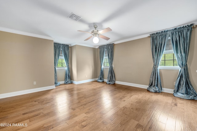 spare room with plenty of natural light, wood-type flooring, and ornamental molding