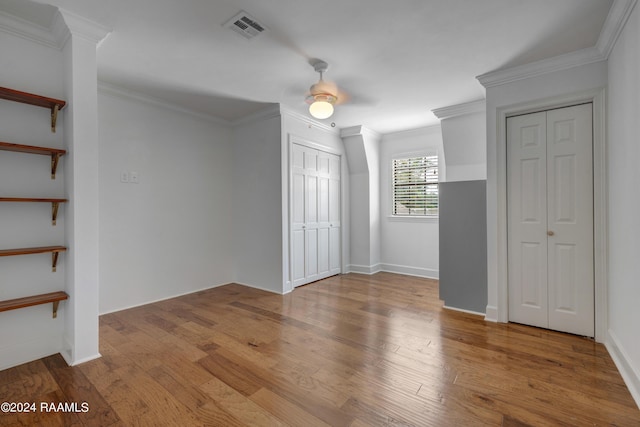 120 Kimball Dr, Lafayette, LA 70508 - unfurnished bedroom with multiple closets, wood finished floors, crown molding, a ceiling fan, and baseboards