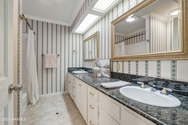 bathroom with a skylight, tile patterned floors, crown molding, shower / bath combination with curtain, and vanity