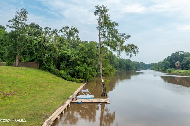 view of dock featuring a lawn and a water view