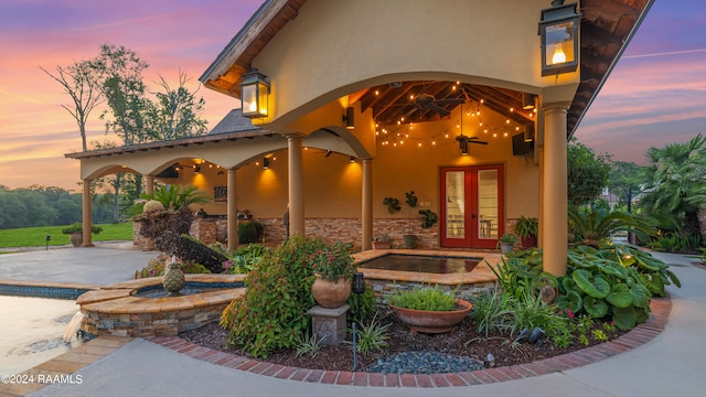 exterior entry at dusk with french doors and a patio