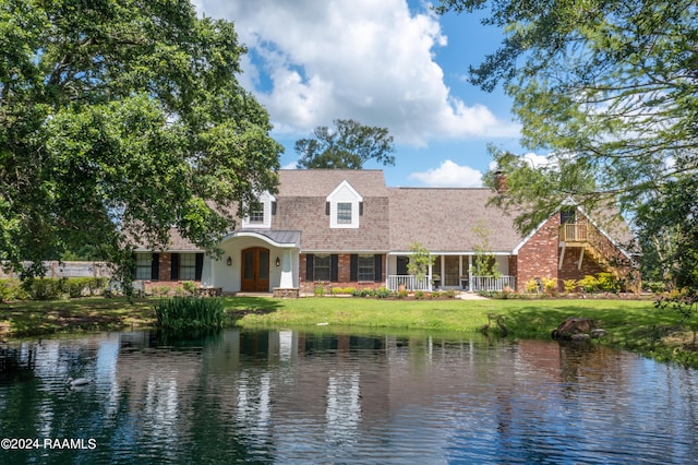 view of front facade with a water view and a front lawn