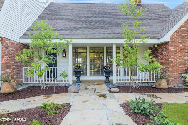 120 Kimball Dr, Lafayette, LA 70508 - view of exterior entry with roof with shingles, covered porch, and brick siding