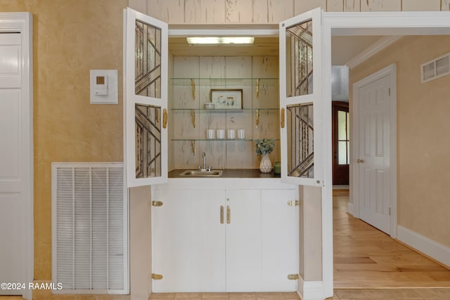 interior space featuring hardwood / wood-style flooring, ornamental molding, and sink