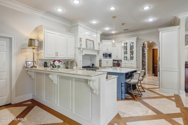 kitchen with stainless steel appliances, kitchen peninsula, decorative light fixtures, a breakfast bar area, and white cabinets