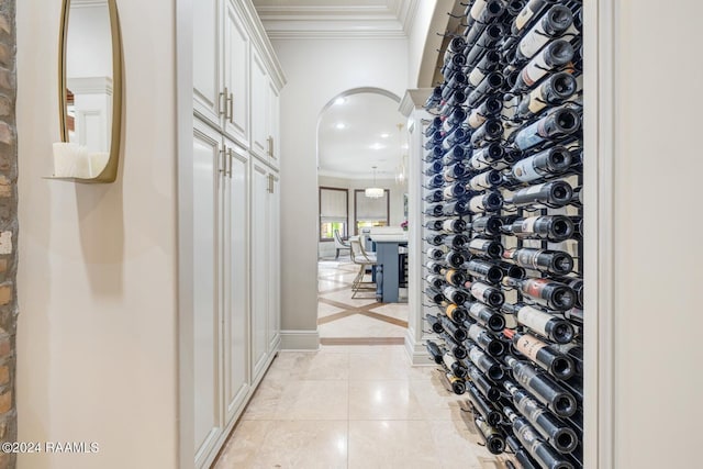 wine room featuring ornamental molding and light tile patterned flooring