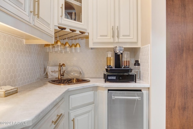 kitchen with white cabinetry, sink, and tasteful backsplash