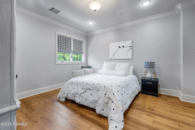 bedroom with hardwood / wood-style floors and ornamental molding