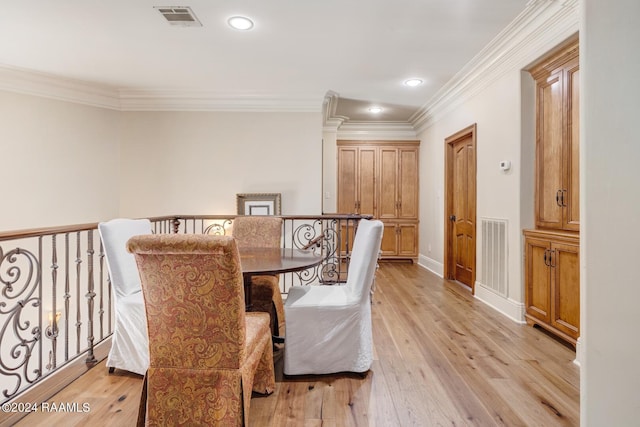 dining space featuring light wood-type flooring and ornamental molding